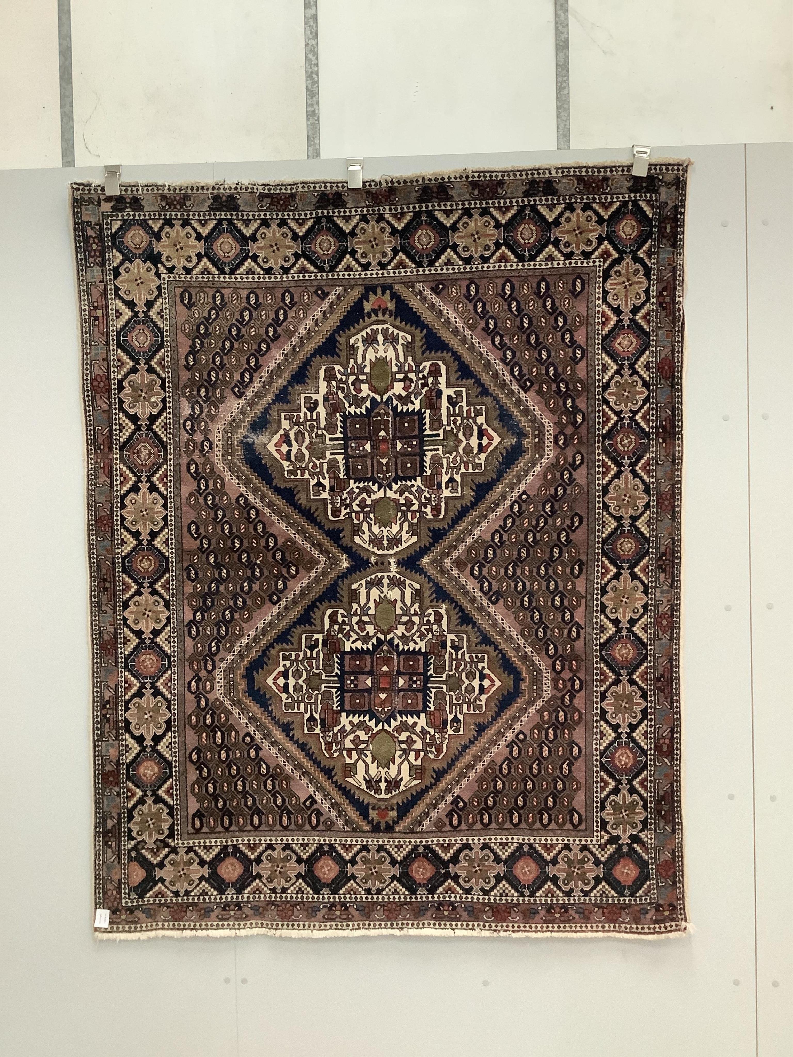 A Persian mauve ground rug, 139 x 174cm. Condition - poor